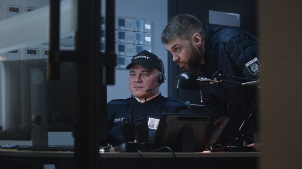 Security professionals reviewing surveillance monitors